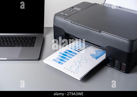 Printer and laptop on grey table in office Stock Photo