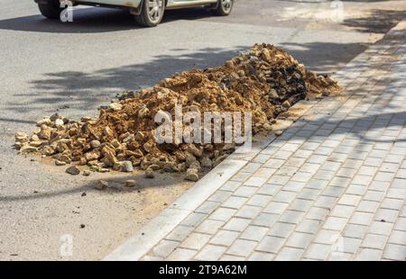 A pile of rocks and sand on the side of the road. Preparation for the repair of the road surface Stock Photo