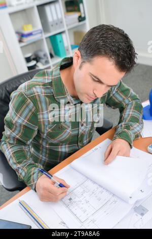 Man at desk working on plans in file Stock Photo
