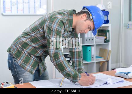 Builder making notes on paperwork Stock Photo