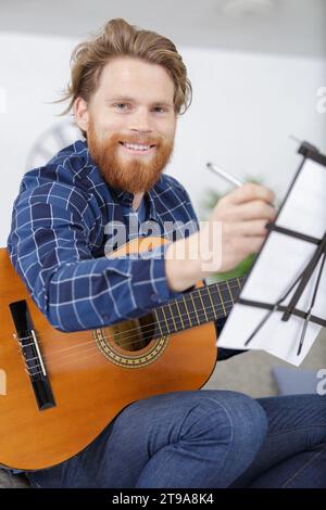 attractive bearded man learning a song Stock Photo