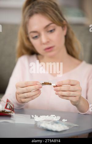 teenage girl hand rolling a cigarette Stock Photo