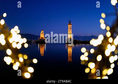 Lindau, Germany. 23rd Nov, 2023. The harbor entrance in Lindau on Lake Constance (Bavaria) with the famous lighthouse and the Bavarian Lion photographed from the 'Lindauer Hafenweihnacht' Christmas market opposite. Credit: Ulf Vogler/dpa/Alamy Live News Stock Photo