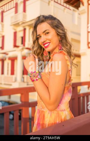 Vertical portrait of a beauty blonde woman in summer dress looking at camera smiling Stock Photo