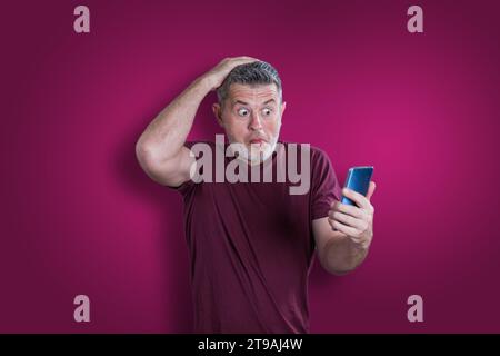 Confused serious man using mobile phone. Emotion concept Stock Photo