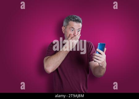 Confused serious man using mobile phone. Emotion concept Stock Photo