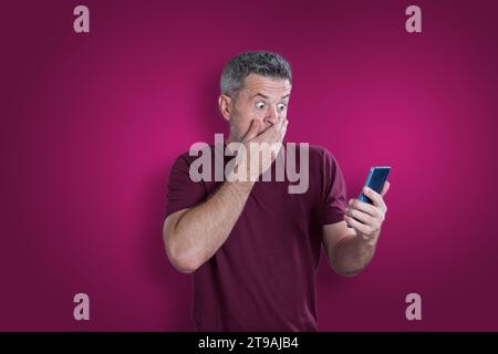 Confused serious man using mobile phone. Emotion concept Stock Photo