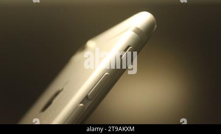 Close up look of side profile of smartphone alumunium showing mute switch and volume button Stock Photo