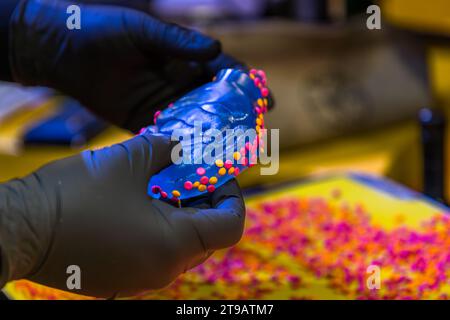 The pre-tempered vinyl puck can be coated with coloured granulate before the record is pressed. Vinyl pressing production facility of the record label Third Man Records / Third Man Pressing Production site of the record label Third Man Records / Third Man Pressing in Detroit, United States. Third Man Pressing's vinyl manufacturing plant is located in Detroit's Cass Corridor.. Vinyl pressing production facility of the record label Third Man Records / Third Man Pressing Stock Photo