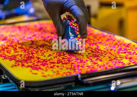 The pre-tempered vinyl puck can be coated with coloured granulate before the record is pressed. Vinyl pressing production facility of the record label Third Man Records / Third Man Pressing Production site of the record label Third Man Records / Third Man Pressing in Detroit, United States. Third Man Pressing's vinyl manufacturing plant is located in Detroit's Cass Corridor.. Vinyl pressing production facility of the record label Third Man Records / Third Man Pressing Stock Photo