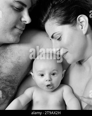 Family in bed with baby Stock Photo