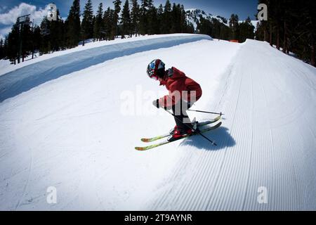 Young skier dropping into a half pipe. Stock Photo