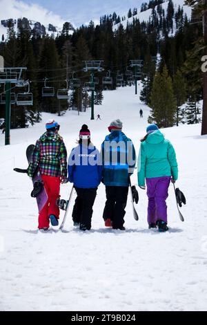 Three snowboard students listening to their snowboard instructor. Stock Photo