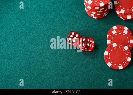 Casino dice game background with two and red chips isolated on green felt mat. Top view. Stock Photo