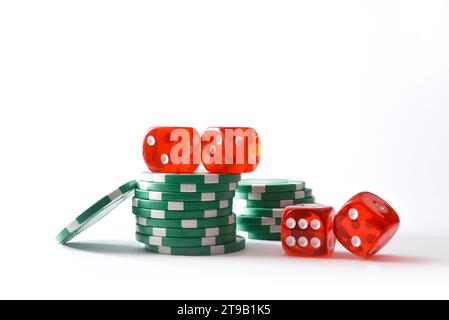 Casino dice game background with stack of green chips for betting and red dice around on white base and white isolated background. Front view. Stock Photo
