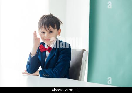 Boy Pupil Schoolboy Raises Hand to Answer in Classroom At Desk Education Knowledge Stock Photo