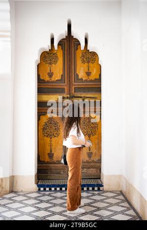 Stunning view of a girl visiting the Bahia Palace during a sunny day. The Bahia Palace in Marrakech is an impressive example of Moroccan architecture Stock Photo