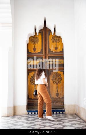 Stunning view of a girl visiting the Bahia Palace during a sunny day. The Bahia Palace in Marrakech is an impressive example of Moroccan architecture Stock Photo