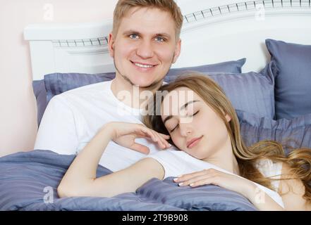 Young happy couple in bed, family in bedroom after sleep, weekend Stock Photo