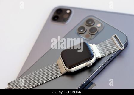 KYIV, UKRAINE - 4 MAY, 2023: Apple brand devices iphone, ipad with apple watch lies on macbook body close up Stock Photo