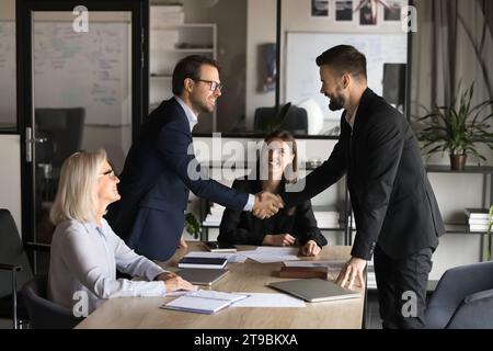 Two happy confident business partners men shaking hands Stock Photo