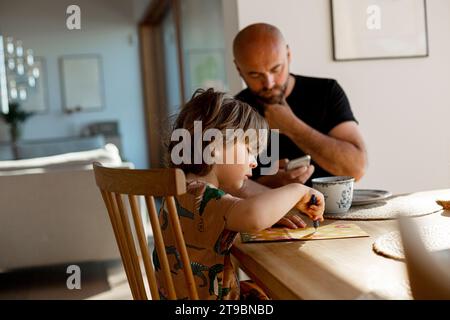 Father and son sitting at table Stock Photo