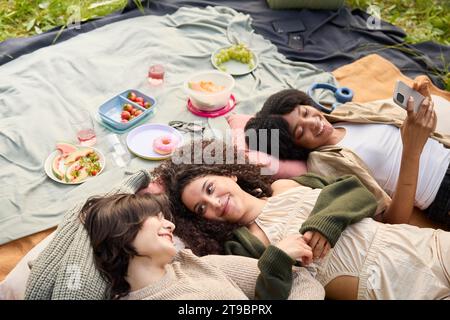 Happy teenage girls relaxing at picnic Stock Photo