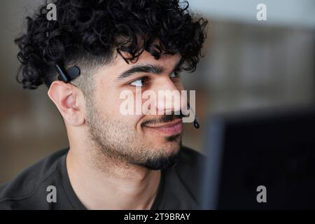 Smiling man wearing headset looking away Stock Photo
