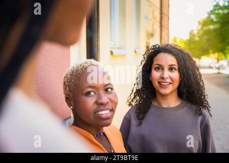Smiling multiracial female friends talking with each other Stock Photo