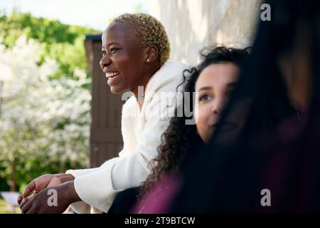 Cheerful young woman sitting with female friends Stock Photo