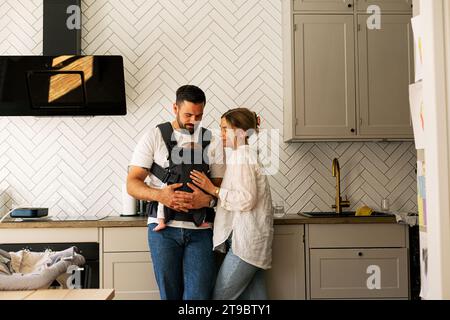 Father and mother with son in kitchen at home Stock Photo