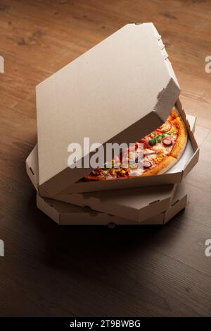 Pizza in open carton box on natural wooden table high angle view with copy-space Stock Photo