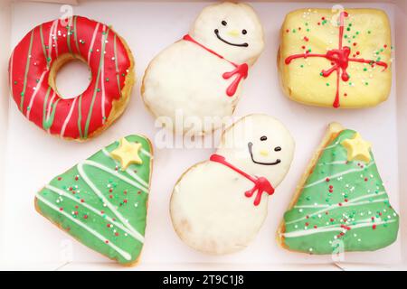 Paper Box Filled with Delectable Assorted Christmas Decorated Doughnuts Stock Photo