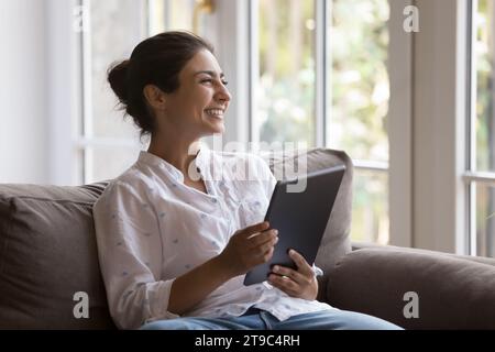 Happy Indian woman using digital tablet at home Stock Photo