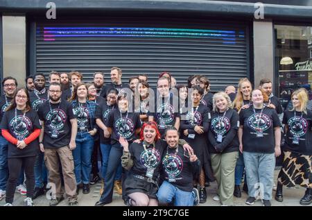 London, UK. 24th November 2023. Staff pose for a photo outside HMV on Oxford Street ahead of its reopening. The iconic entertainment store returns to its flagship location at 363 Oxford Street after four years. Credit: Vuk Valcic/Alamy Live News Stock Photo