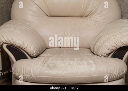 Defects on a white leather sofa. Damaged to leather furniture. Stock Photo