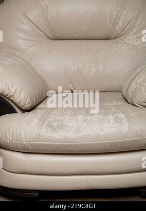 Defects on a white leather sofa. Damaged to leather furniture. Stock Photo