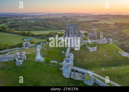 Aerial view of the abandoned ruins of Corfe Castle at dawn, Dorset, England.  Summer (June) 2021. Stock Photo