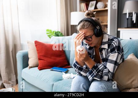 Sad tired young woman touching forehead having headache migraine or depression, upset frustrated girl troubled with problem feel stressed cover crying Stock Photo