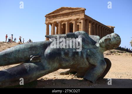 Modern bronze statue of Icarus made by Polish artist Igor Mitoraj lying in front of the Temple of Concordia in Agrigento, the Valley of the Temples. Stock Photo