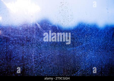 pattern of small raindrops against a clear blue toned surface Stock Photo