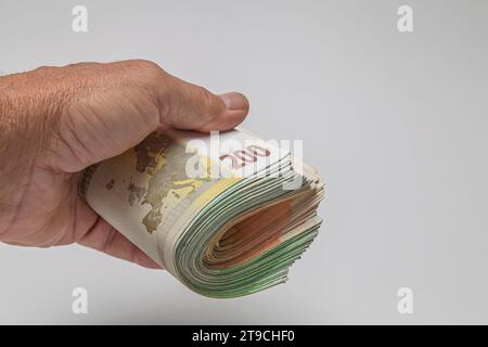 Hand holding a stack of euro banknotes on a white background Stock Photo
