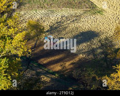 crawled tractor plow arid dry soil on the hill of Arda Valley, Italy, to seed wheat during autumn season in november Stock Photo