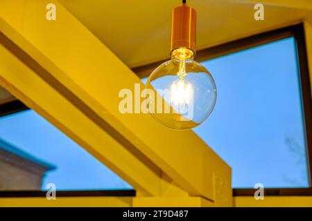 Ceiling lamp without a dome, minimalism in the interior of the room. Stock Photo