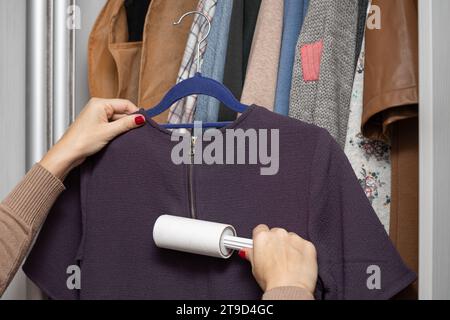 woman cleaning clothes with a wool roller. roller for cleaning clothes Stock Photo