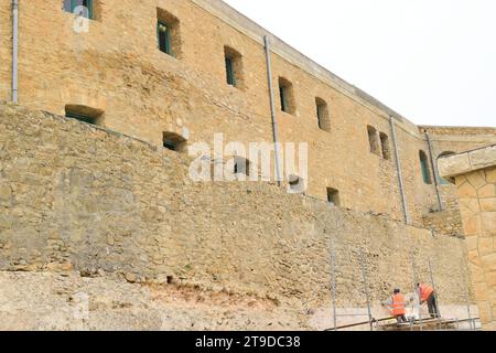 non edited picture of workers working on renewing and renovation of old history buildings castle walls Stock Photo