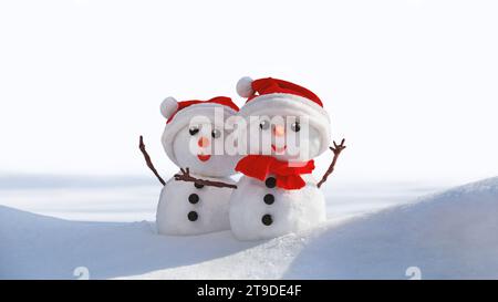 View of a couple of snowmen in a santa hats on their heads, isolated on white background. Holiday christmas background with copy space for text Stock Photo