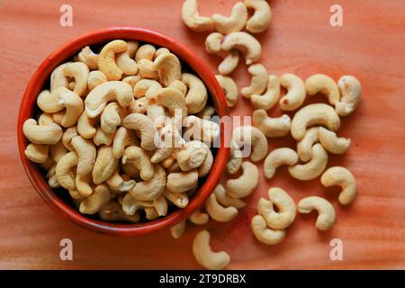 Roasted cashew nuts in a bowl on a wooden table background. Nuts background Stock Photo