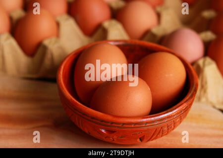 Fresh eggs in a bowl on a wooden table. Selective focus. Stock Photo