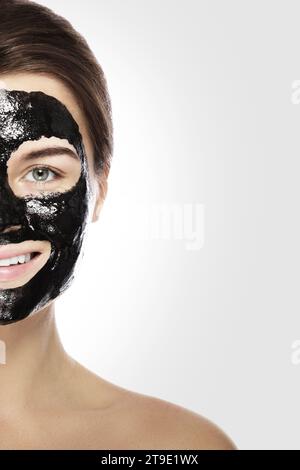 Young woman with deep cleansing black mask on her face Stock Photo